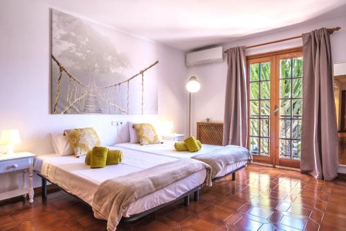 a bedroom with two beds and a bridge painting on the wall at Casa Mamita Ibiza in Sant Jordi