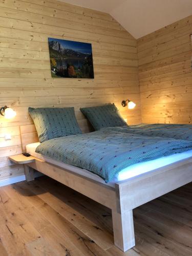 a bedroom with a bed in a wooden wall at Ausseer Chalet (nahe Hallstatt), Appartements in Bad Aussee