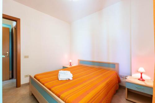 a bedroom with a bed with two towels on it at Appartamenti Cavour cod C in Villasimius