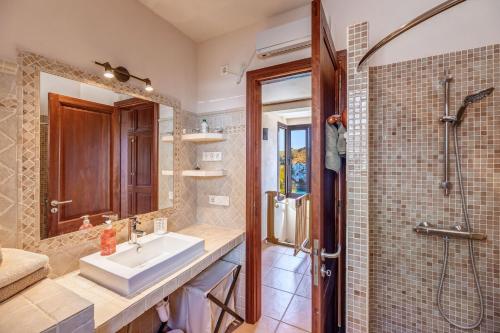 un baño con lavabo y ducha en Villa Calima, en Cala Romántica