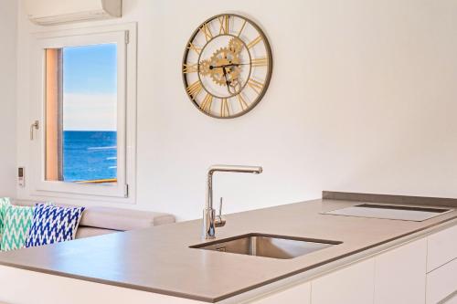 a kitchen with a sink and a clock on the wall at Apartamento Mirador in Cala de Sant Vicenc