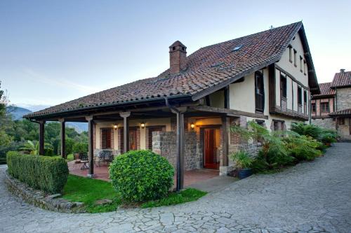 a house with a tiled roof on a street at La Montaña Mágica Hotel Rural in Vibaño