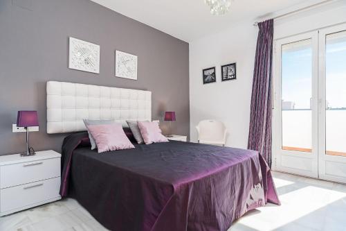 コニル・デ・ラ・フロンテーラにあるDúplex tejar D piscinas y familiasのピンクの枕が付いた大きなベッドのある寝室