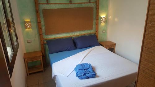 ein Schlafzimmer mit einem Bett mit einem blauen Handtuch darauf in der Unterkunft Bilocale 50 mt. dalla spiaggia 27 in Torre dell'Orso