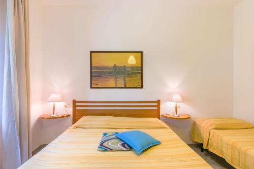 カンポ・ネッレルバにあるCasa Lucia Marina di Campoのランプ2つ付きの部屋のベッド2台