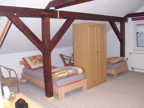 Zimmer mit 2 Betten und 2 Stühlen in der Unterkunft Ferienwohnung Am Dorfplatz in Lutherstadt Wittenberg