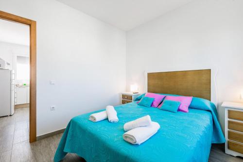 コニル・デ・ラ・フロンテーラにあるApartamento La Higuera 2のベッドルーム1室(ピンクとブルーの枕が付いた青いベッド1台付)