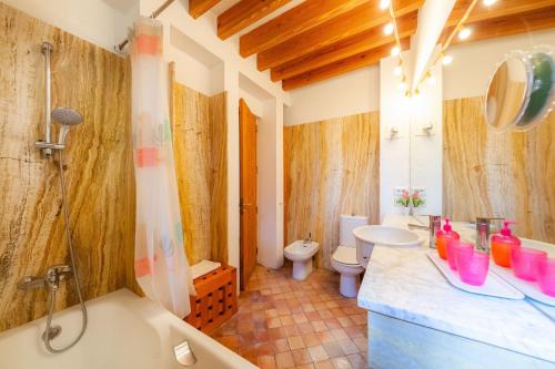 a bathroom with a tub and a sink and a toilet at Villa Cala Bona in Cala Bona