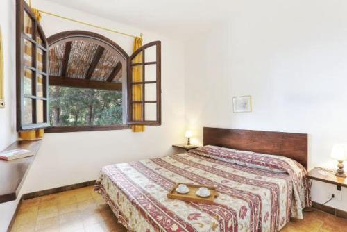 a bedroom with a bed and a large window at Villa Artistica app.3/bilo4 (bilocale) in Capoliveri