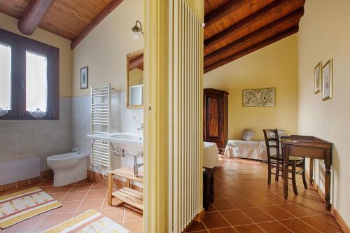 bagno con lavandino, servizi igienici e scrivania. di Casa Soliana a Castiadas