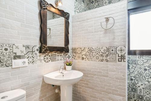 a white bathroom with a sink and a mirror at Chalet Rubio Cabeza in Conil de la Frontera