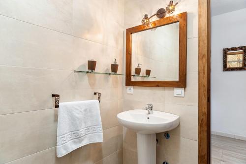 un baño con lavabo y espejo en Casa El Duque, en Vejer de la Frontera