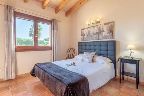 Un dormitorio con una cama grande y una ventana. en Can Siurell, en Artà