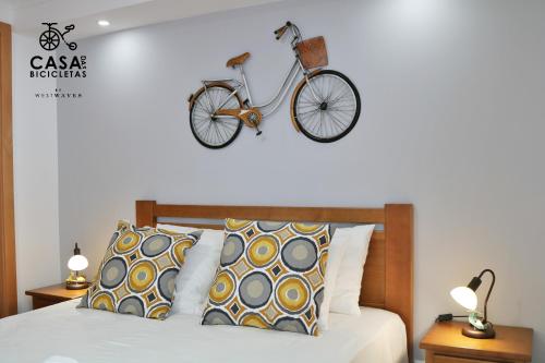 ペニシェにあるCasa das Bicicletasのベッドルーム1室(ベッド1台付)、壁に自転車1台が備わります。