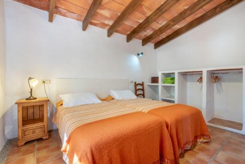 a bedroom with a large bed with an orange blanket at Es Rafal Roig - Es Cestador in Sant Llorenç des Cardassar