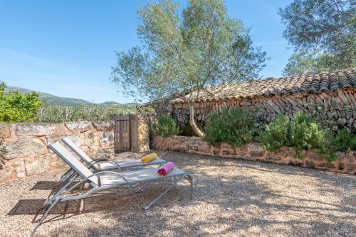 a chair sitting in a yard next to a stone wall at Es Rafal Roig - Es Cestador in Sant Llorenç des Cardassar