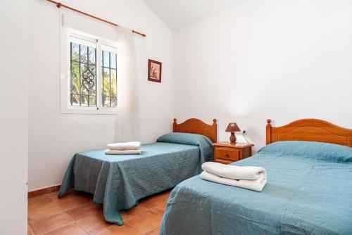 a bedroom with two twin beds and a window at Casa Palillero - Sólo Familias in Conil de la Frontera