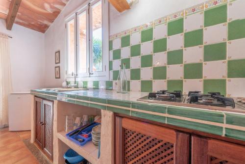 a kitchen with a green and white tiled wall at Es Rafal Roig - Es Cestador in Sant Llorenç des Cardassar