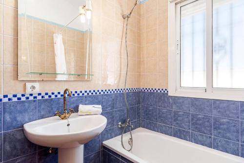 a blue tiled bathroom with a sink and a tub at Casa Palillero - Sólo Familias in Conil de la Frontera