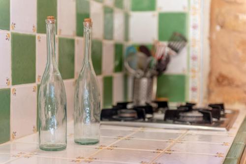 three glass bottles sitting on a counter next to a stove at Es Rafal Roig - Es Cestador in Sant Llorenç des Cardassar