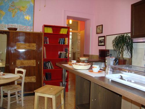 cocina con encimera y estantería de libros rojos en La Maison des Livres, en Reggio Calabria