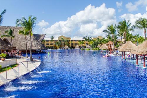 a swimming pool at a resort with palm trees at Barceló Maya Palace - All Inclusive in Xpu Ha