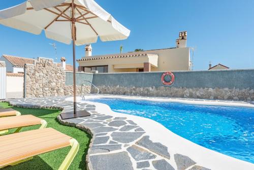 a swimming pool with a table and an umbrella at Bungalows La Aceitera - Casa 2 in Zahora
