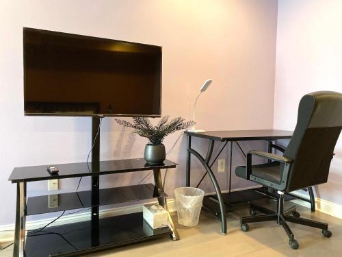 a television on a stand with a desk and a chair at Alina & Fanny - Philadelphia 1210 Mt Vernon St in Philadelphia
