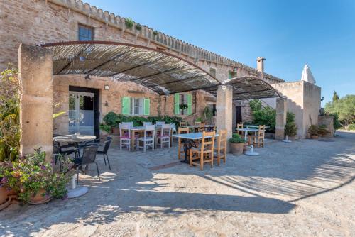 a patio with tables and chairs under a bridge at Es Rafal Roig - Es Nord in Sant Llorenç des Cardassar