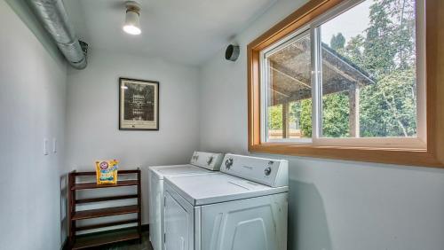 eine Waschküche mit einer Waschmaschine und einem Fenster in der Unterkunft Sehome Garden Inn in Bellingham