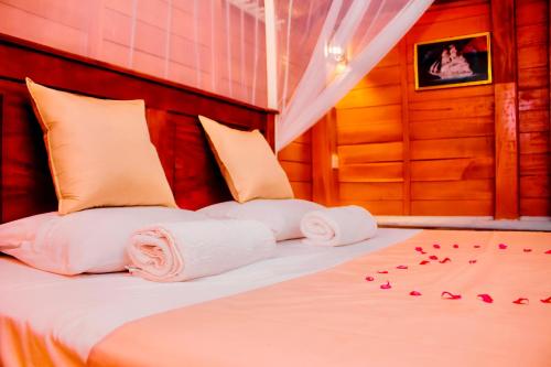 a bed with towels and rose petals on it at Star Light Cabanas & Restaurant in Tangalle