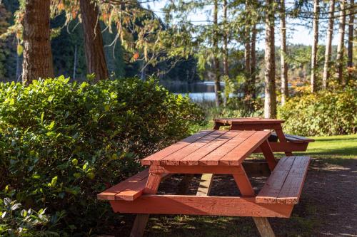 two picnic tables in a park next to a lake at Cusheon Lake Resort in Ganges