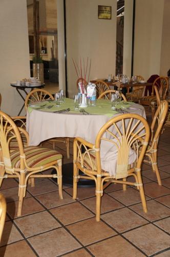 a table in a restaurant with chairs and a table with a white table cloth at Casa Grande Chihuahua in Chihuahua