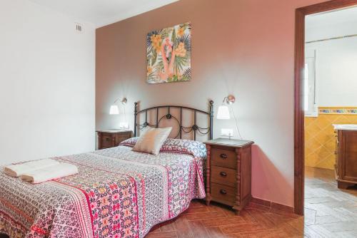 a bedroom with a bed and a dresser and a picture at Casa Familiar La Lobita 1 in Conil de la Frontera