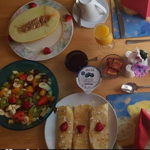 a table topped with plates of food and a bowl of salad at Clare Street B&B in Nenagh