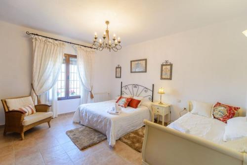 um quarto com uma cama, um sofá e uma cadeira em Villa Quilin em Alhaurín el Grande