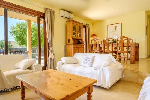 sala de estar con sofá blanco y mesa en Villa Sunrise, en Sant Josep de sa Talaia