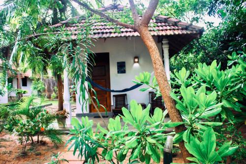a house with a blue hose in front of it at Star Light Cabanas & Restaurant in Tangalle