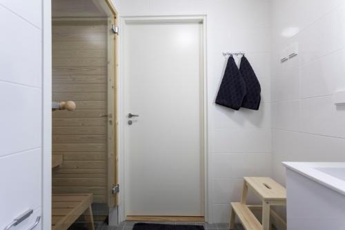 een badkamer met een douche en een witte deur bij Tuomas´ luxurious suites, Mustikka in Rovaniemi