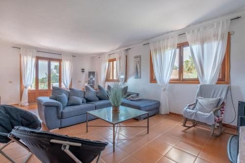 a living room with a blue couch and chairs at Can Cancus in Capdepera