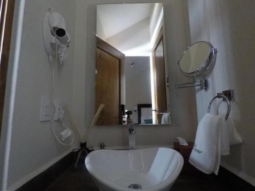 a bathroom with a white sink and a mirror at Hotel Villa Murano in San Cristóbal de Las Casas