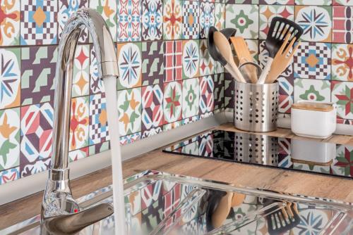 a kitchen with a sink and a tile wall at House Sun Beach 2 in Vejer de la Frontera