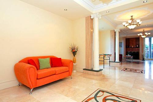 a living room with an orange couch in a room at ABC Accommodation - Rosebud in Rosebud