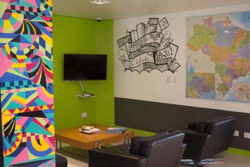 a waiting room with a tv and a map on the wall at Anhembi Hostel in Sao Paulo