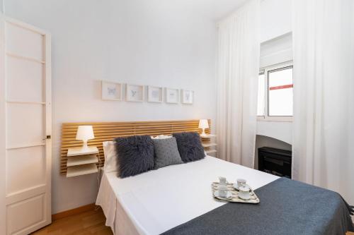 Un dormitorio blanco con una cama grande con zapatos. en La Torre de Menacho, en Cádiz