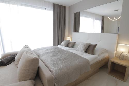 a bedroom with a white bed and a large window at Apartmány ROSE Mikulov in Mikulov