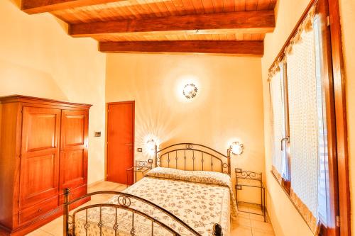 una camera con letto e armadio in legno di Agriturismo Rocce Bianche ad Arbus