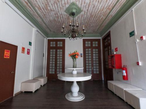 a room with a table with a vase of flowers on it at Pariwana Hostel Santiago in Santiago