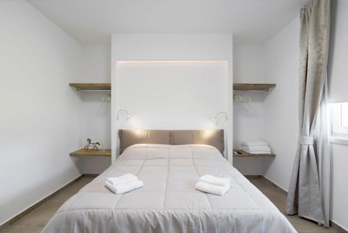 a bedroom with a white bed with two towels on it at Appartamenti Dama 1 in Bardolino
