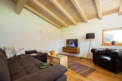 a living room with a couch and a tv at Ferienwohnung Leitinger in Sankt Martin bei Lofer